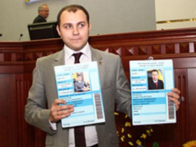 Председатель областного отделения Всеукраинского студенческого совета Евгений Лапенко демонстрирует огромные студенческие билеты губернатора и главы облсовета.
