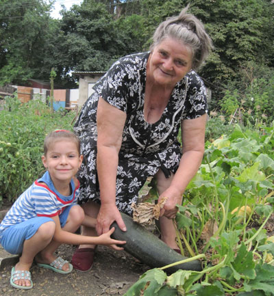 Бабушка с внучкой на огороде. Донбасс