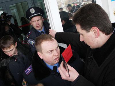 Депутат Дмитрий Верзилов тщетно пытается с помощью своего удостоверения попасть внутрь здания областной госадминистрации. 