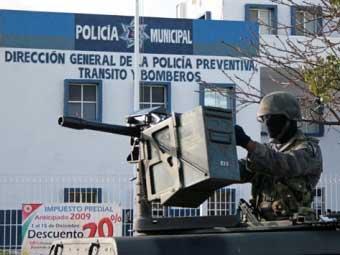 Мексиканский военнослужащий возле здания полиции Канкуна.